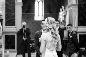 Mariée vue de dos portant une robe de mariée sur mesure lors de la cérémonie à l'église